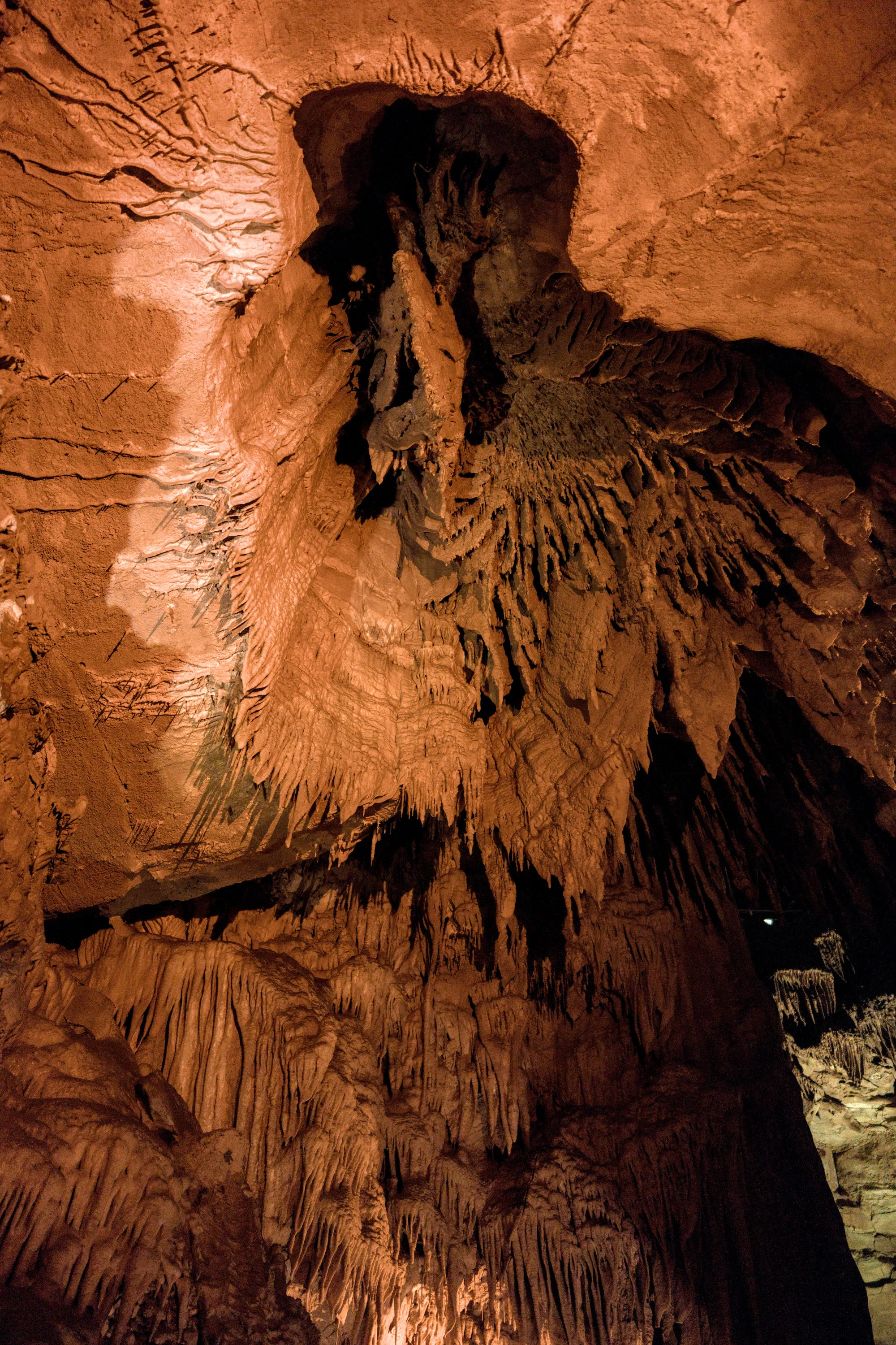 Rock formations in a cave, lit orange.